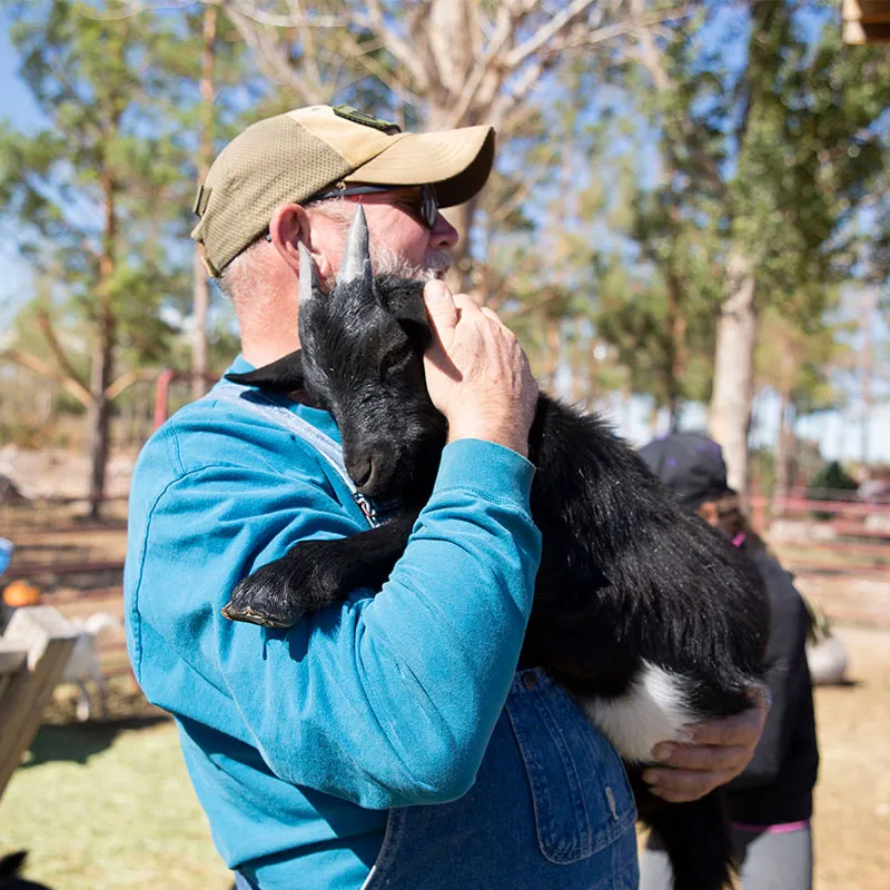 Staff member and goat at Harvest Farm.