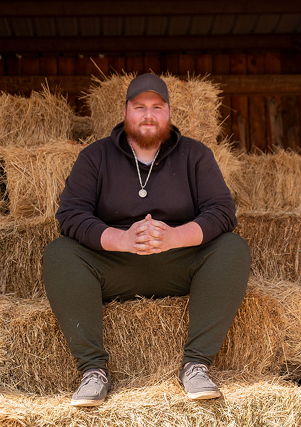 Dan sitting on hay bales