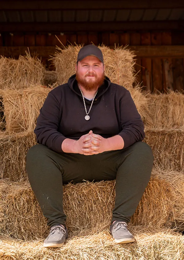 Dan sitting on hay bales